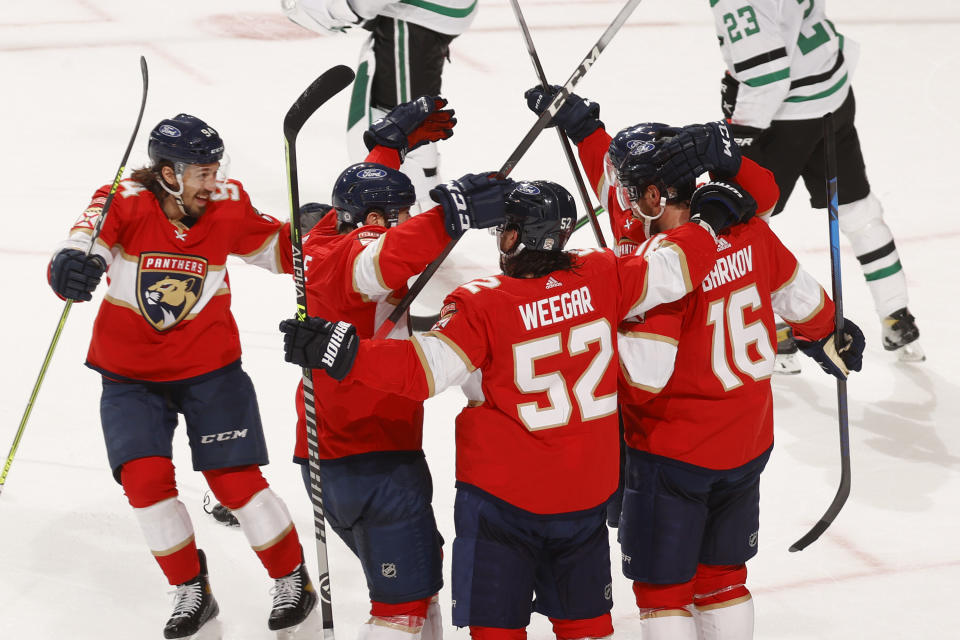 Teammates celebrate the game-winning goal by Florida Panthers center Aleksander Barkov (16) during the overtime period of an NHL hockey game, Monday, May 3, 2021, in Sunrise, Fla. (AP Photo/Joel Auerbach)