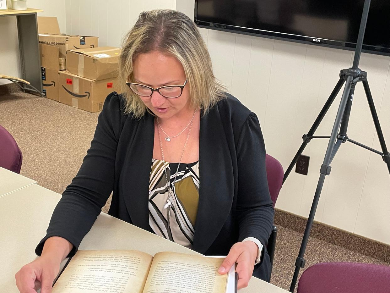 United Way of Pekin Executive Director Heather Robertson reads local historian Carl Adams' book “Nance: Trials of the First Slave Freed by Abraham Lincoln: A True Story of Mrs. Nance Legins-Costley.”