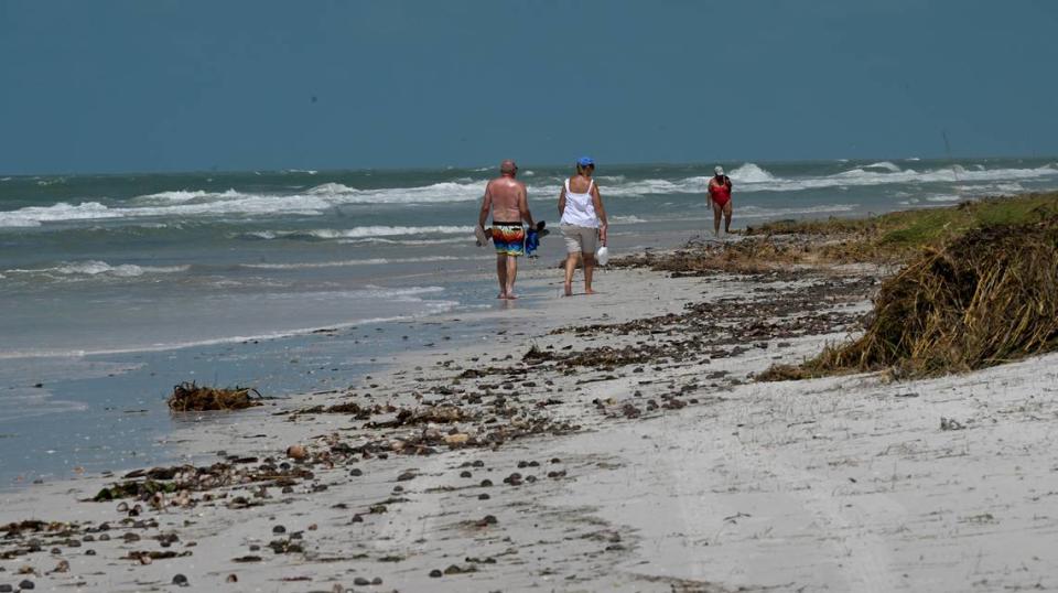 Beachcombers walk along the shore near Bean Point after Hurricane Idalia passed on August 31, 2023.