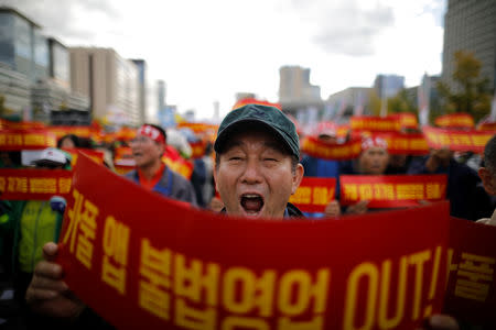 A taxi driver takes part in a protest against a carpool service application that will be launched by Kakao Corp later this year, in central Seoul, South Korea, October 18, 2018. The banners read, "Stop carpool service application, it is illegal business". REUTERS/Kim Hong-Ji