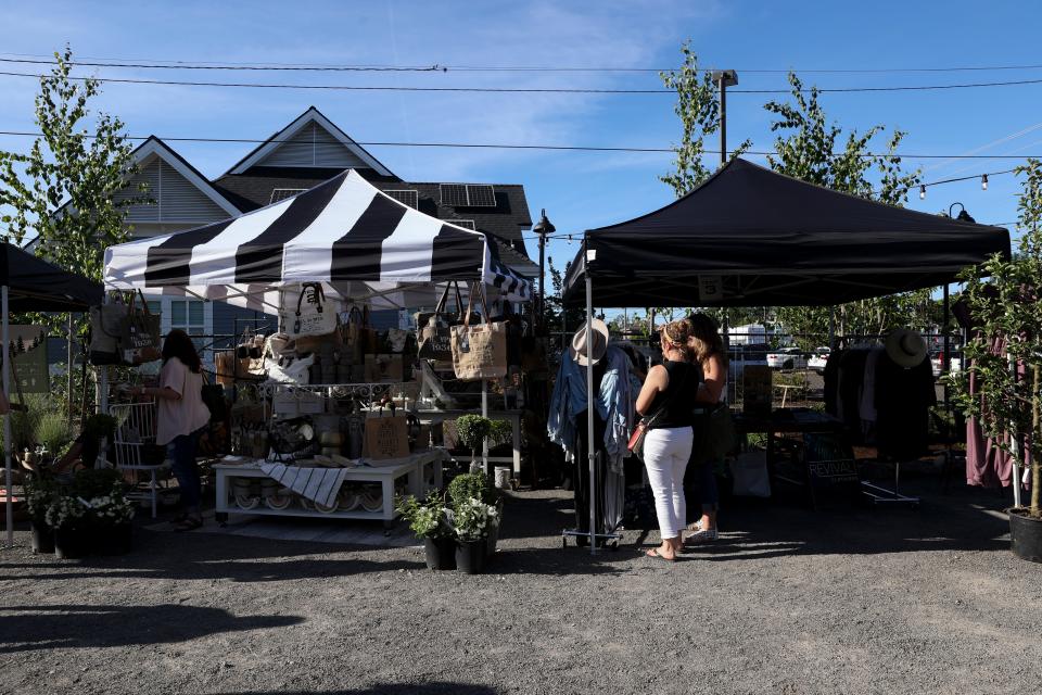 Los clientes examinan detenidamente diferentes puestos en el Mercado Nocturno instalado fuera de Furbish en Salem el 29 de mayo de 2021.