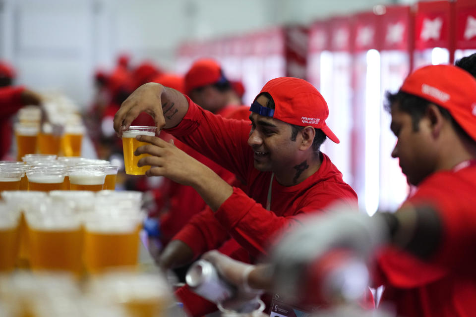 FILE - Staff member holds a beer at a fan zone ahead of the FIFA World Cup, in Doha, Qatar Saturday, Nov. 19, 2022. (AP Photo/Petr Josek, File)