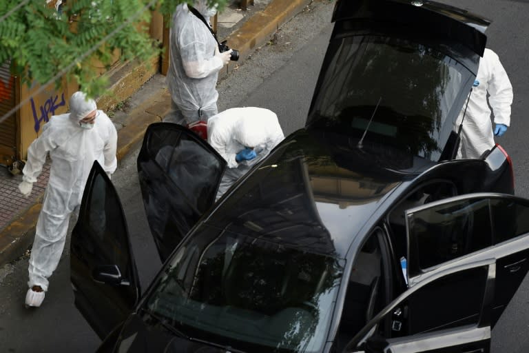 Greek forensic experts inspect former PM Lucas Papademos's car after the letter bomb attack in Athens in May