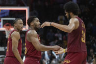 Donovan Mitchell de los Cavaliers de Cleveland (centro) es felicitado por su compañero de equipo Jarrett Allen (derecha) ante la mirada de Isaac Okoro en el cierre de la segunda mitad del juego de baloncesto de la NBA ante los Pacers de Indiana, en Cleveland, el viernes 12 de abril de 2024. (AP Foto/Phil Long)