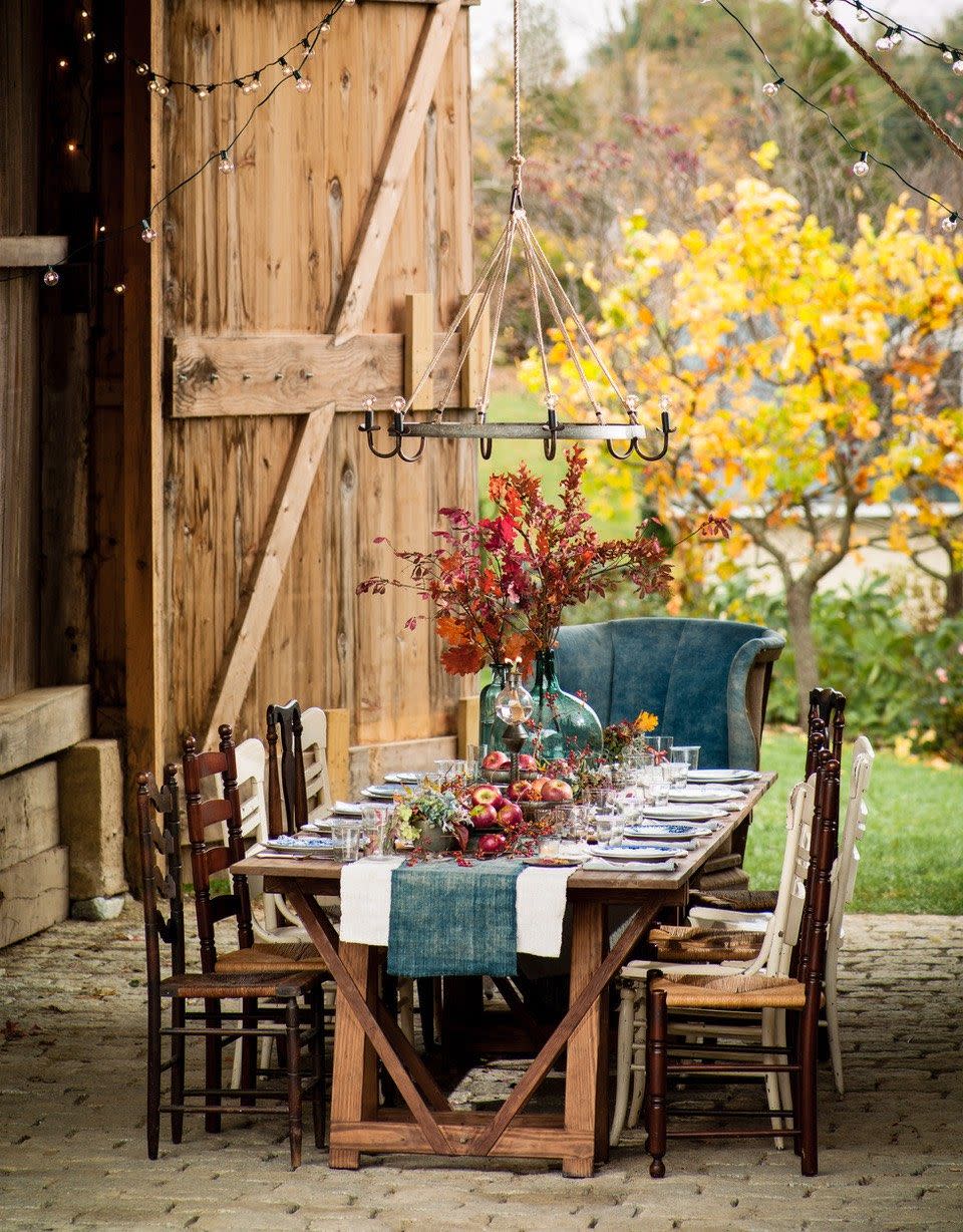 <p>A large jug filled with fall foliage and stacks of apples are the final touches that make this outdoor Thanksgiving table by Helen Norman of <a href="https://www.starbright-farm.com/" rel="nofollow noopener" target="_blank" data-ylk="slk:Star Bright Farm;elm:context_link;itc:0;sec:content-canvas" class="link ">Star Bright Farm</a> a dreamy holiday escape.</p>