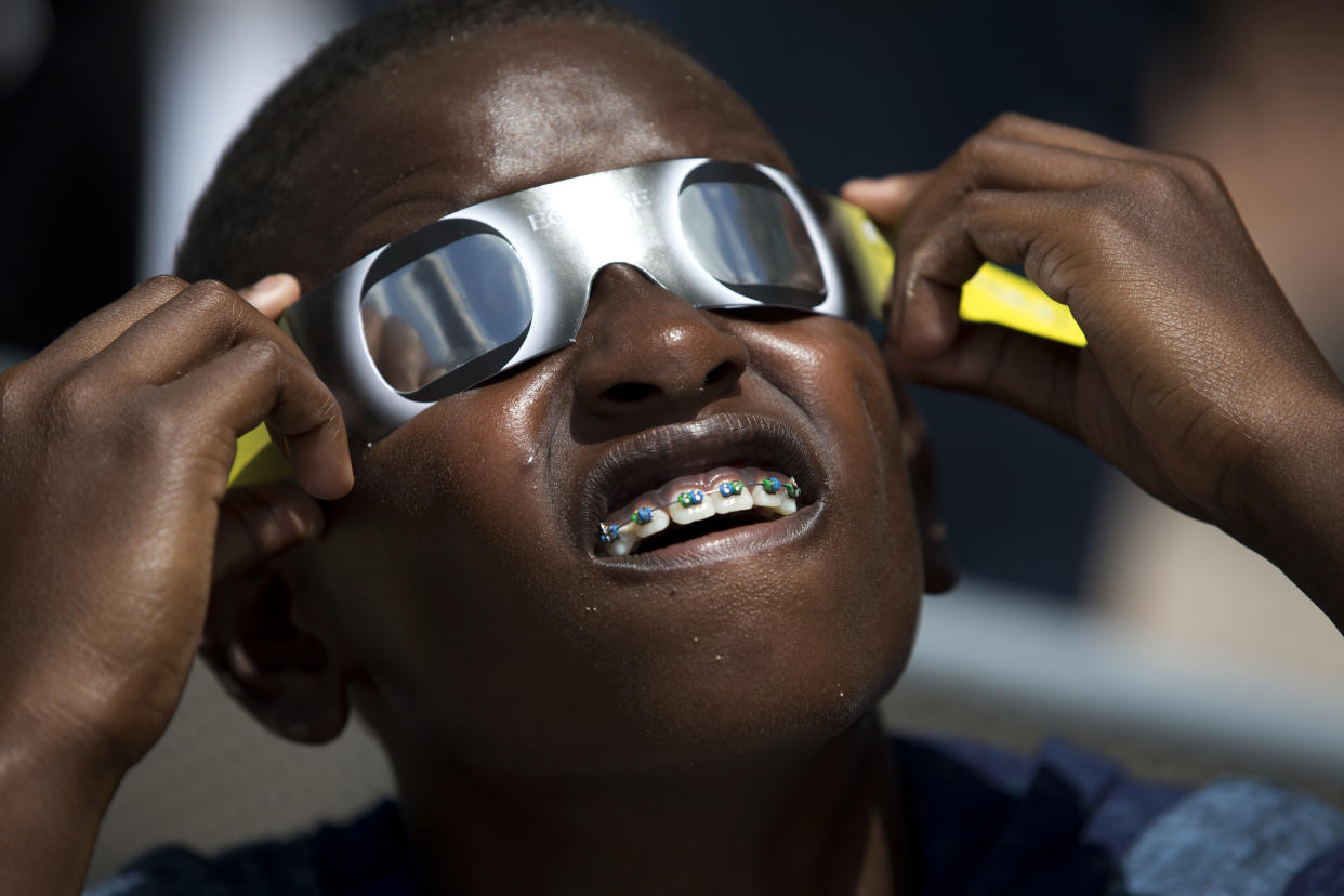 A boy looks through solar glasses as he watches the eclipse in Florida in 2017.