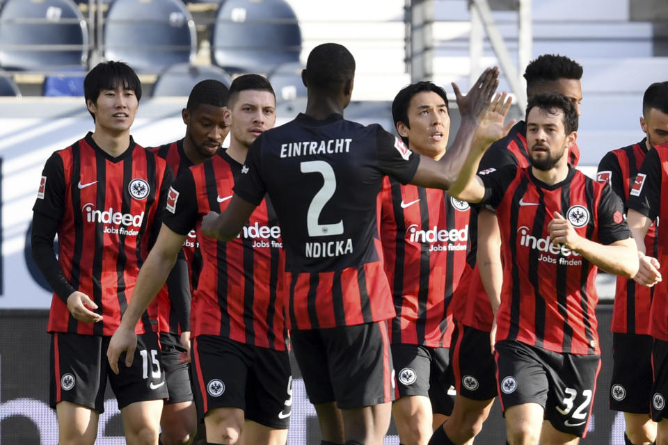 Frankfurt's Daichi Kamada, left, celebrates with team mates after he scores the opening goal during the German Bundesliga soccer match between Eintracht Frankfurt and Bayern Munich in Frankfurt, Germany, Saturday, Feb. 20, 2021. (Arne Dedert/POOL via AP)