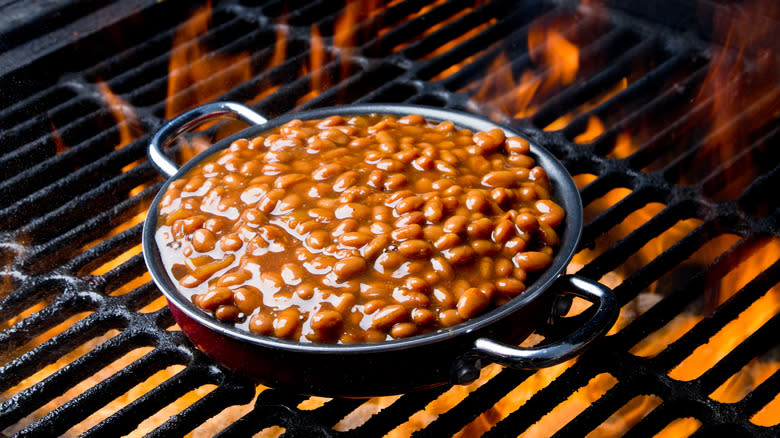 Baked beans cooking on fiery grill
