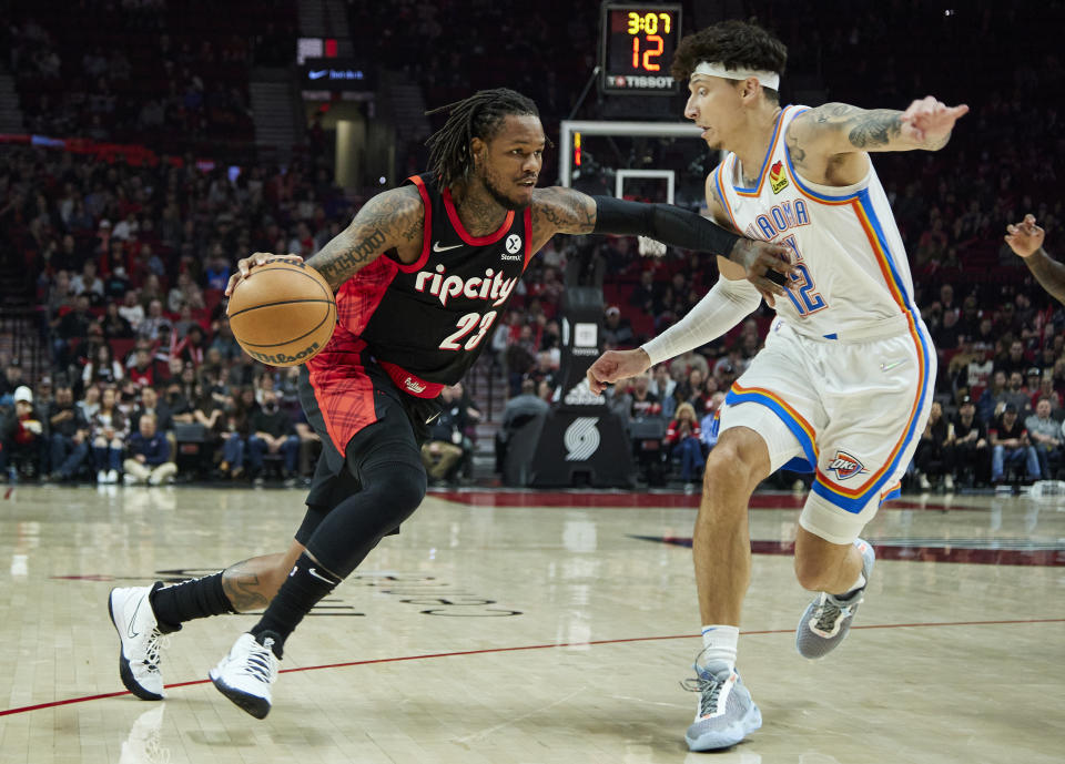 Portland Trail Blazers guard Ben McLemore, left, dribbles around Oklahoma City Thunder forward Lindy Waters III during the first half of an NBA basketball game in Portland, Ore., Monday, March 28, 2022. (AP Photo/Craig Mitchelldyer)