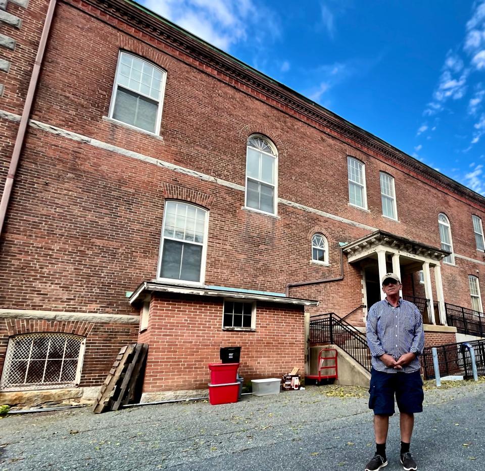 Michael Keene, co-owner of Taunton Antiques Center, stands near the entrance to 45 School St. that serves as a temporary location until structural repairs are completed at Union Block on Main Street.