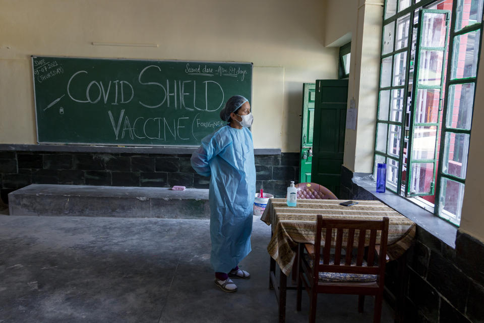 An exile Tibetan nurse puts on her protective suit as she prepares to assist at a COVID-19 vaccination center in Dharmsala, India, Thursday, July 1, 2021. The vaccination was organised by the Himachal Pradesh government for the foreign national residing in the state. (AP Photo/Ashwini Bhatia)