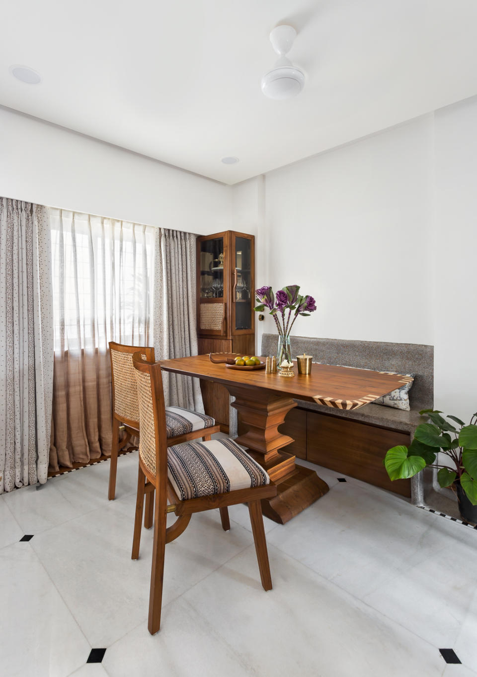 The formal dining area is tucked into a niche. Here, a built-in terrazzo and teak bench doubles as a nifty storage space.