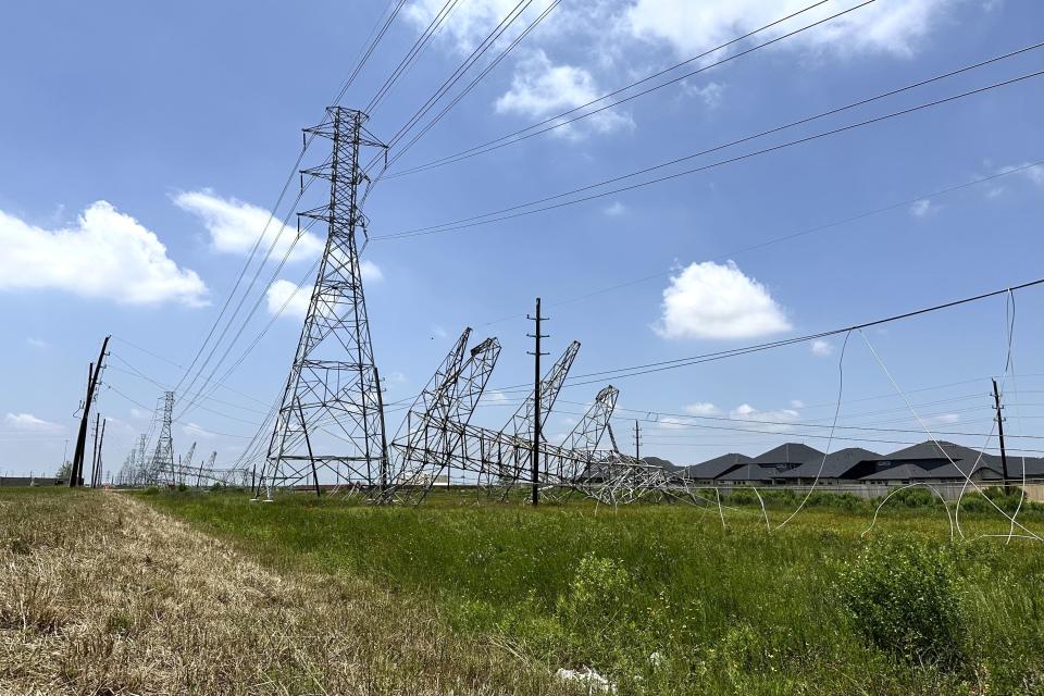 Power transmission lines were twisted and toppled after powerful storms swept through the Houston area on Saturday, May 18, 2024 in Cypress, Texas. As the Houston area works to clean up and restore power to hundreds of thousands, it will do so amid a smog warning and rising Texas heat. (AP photo/Mark Vancleave)
