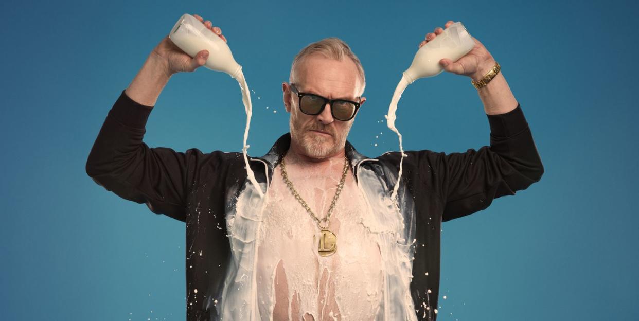 greg davies pouring milk over his chest and shirt in promotional pic for full fat legend comedy tour