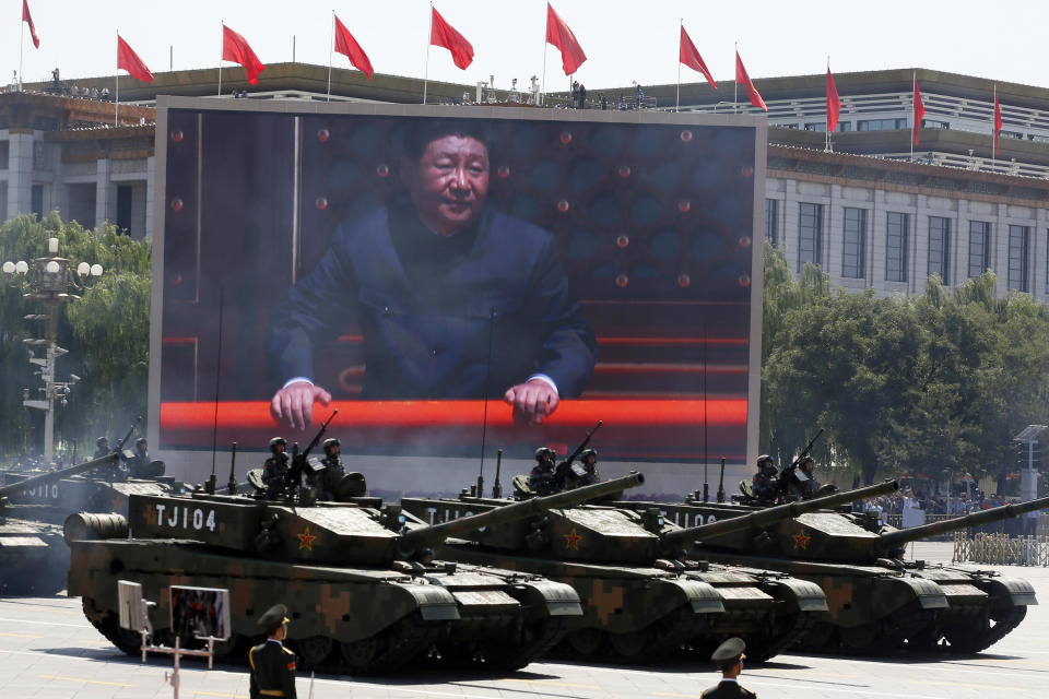 FILE - In this Sept. 3, 2015, file photo, Chinese President Xi Jinping is displayed on a screen as Type 99A2 Chinese battle tanks take part in a parade commemorating the 70th anniversary of Japan's surrender during World War II held in front of Tiananmen Gate in Beijing. Xi has an ambitious goal for China: to achieve "national rejuvenation" as a strong and prosperous nation by 2049, which would be the 100th anniversary of Communist Party rule. One problem: U.S. President Donald Trump wants to make the United States great again too. (AP Photo/Ng Han Guan, File)