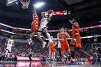 Louisville forward Jordan Nwora (33) shoots as he's defended by Syracuse forward Elijah Hughes (33) during the second half of an NCAA college basketball game Wednesday, Feb. 19, 2020, in Louisville, Ky. Louisville won 90-66. (AP Photo/Wade Payne)