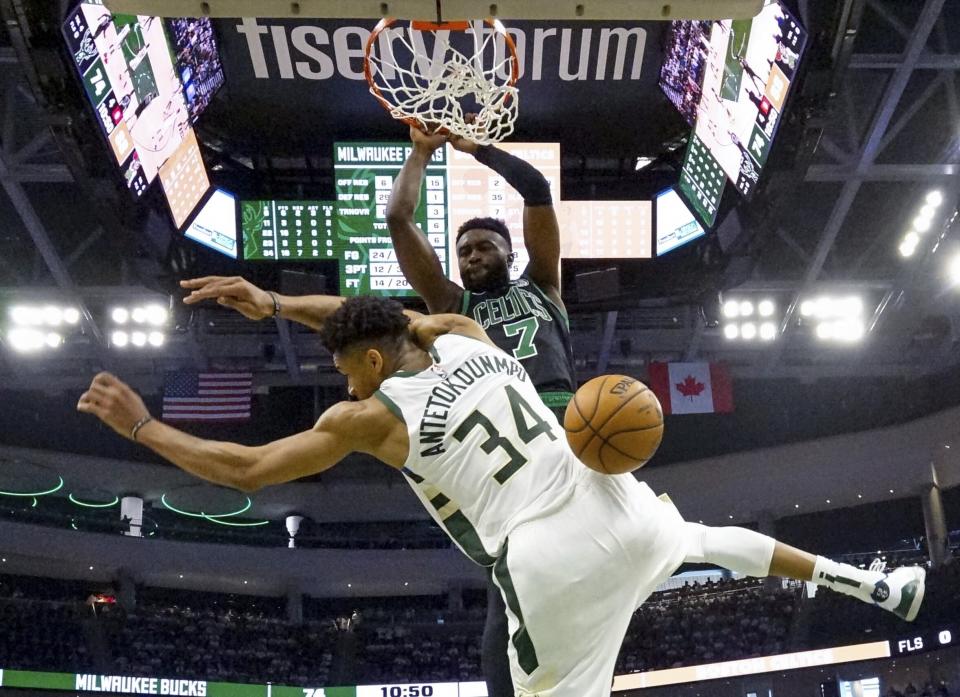 Boston Celtics' Jaylen Brown dunks over Milwaukee Bucks' Giannis Antetokounmpo during the second half of Game 1 of a second round NBA basketball playoff series Sunday, April 28, 2019, in Milwaukee. The Celtics won 112-90 to take a 1-0 lead in the series. (AP Photo/Morry Gash)