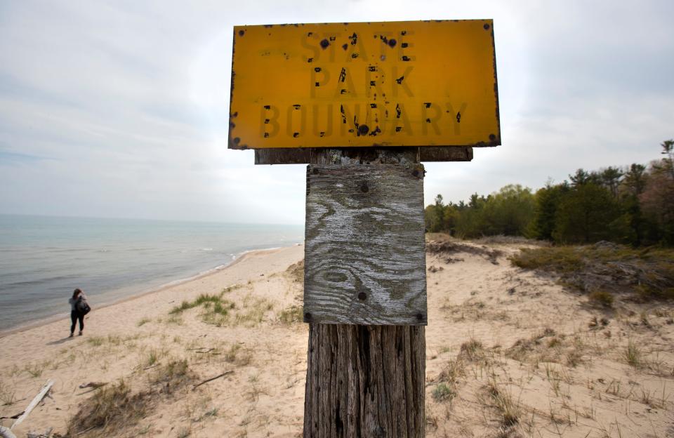 A faded sign marking the northern border of Kohler-Andrae State Park is shown Tuesday, May 18, 2021 in Sheboygan, Wis. The state's Natural Resources Board in 2018 approved a land trade Kohler Co. had negotiated with the Department of Natural Resources nearly 10 acres west of the park for 4.6 acres of the park, and easement over another 1.8 acres of the park. The deal was part of Kohler's plans to add a third championship golf course to the two it already owns, Blackwolf Run and Whistling Straits. Opponents have mentioned that the course will likely require armoring the beach, which will have effects down the shore.