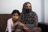 Kariman, 32, sits on a couch with her daughter Layan at their apartment in the northern city of Thessaloniki, Greece, Saturday, May 1, 2021. Sundered in the deadly chaos of an air raid, a Syrian family of seven has been reunited, against the odds, three years later at a refugee shelter in Greece's second city of Thessaloniki. (AP Photo/Giannis Papanikos)