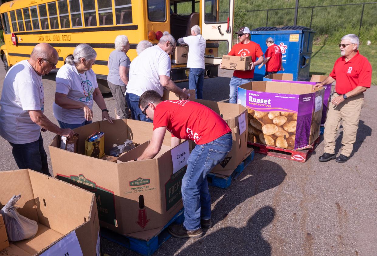 Volunteers with American Electric Power and Caring and Serving Together help unload a Canton Local school bus at the Akron-Canton Regional Foodbank’s Stark County campus Tuesday in Canton. Volunteers helped unload food as part of the seventh annual "Hunger: The Bus Stops Here" fundraising drive.