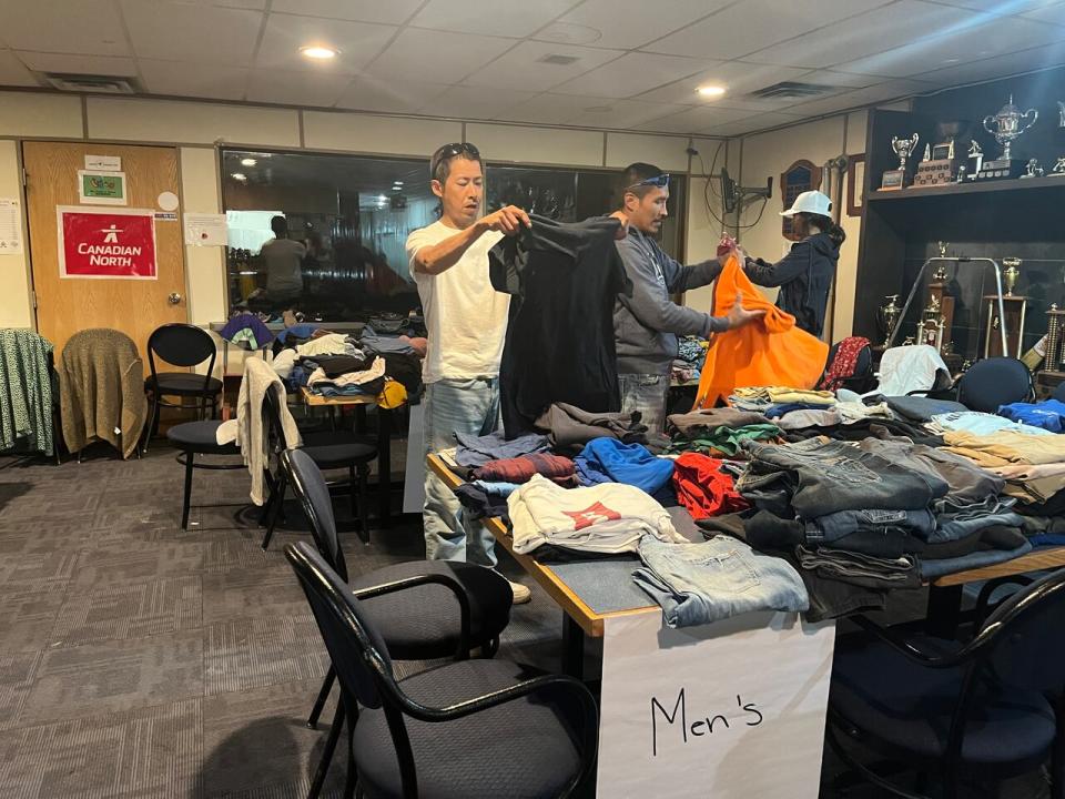 Cameraon Boniface, left, and other Fort Good Hope residents look through donated clothing at the Norman Wells curling rink. 