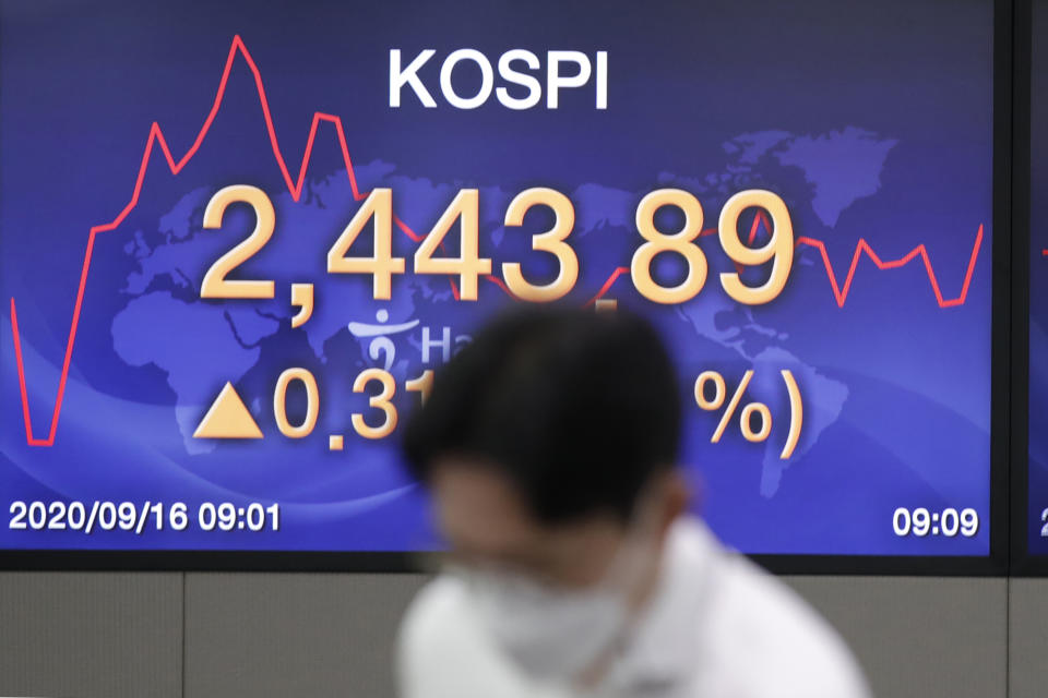 A currency trader stands near a screen showing the Korea Composite Stock Price Index (KOSPI) at the foreign exchange dealing room in Seoul, South Korea, Wednesday, Sept. 16, 2020. Shares were mostly higher in Asia on Wednesday after advances for big technology companies carried Wall Street to further gains overnight. (AP Photo/Lee Jin-man)
