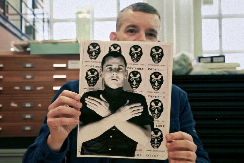 Russell Tovey holds photo of David Robilliard, who poses with prints of his poetry collection ‘Invincible' (The Bishopsgate Library)