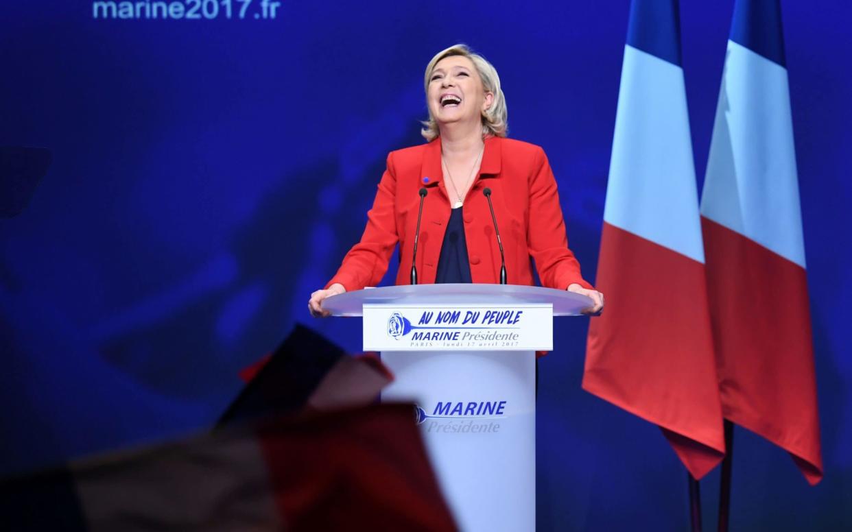 Marine Le Pen reacts on stage during a campaign meeting on April 17 - AFP