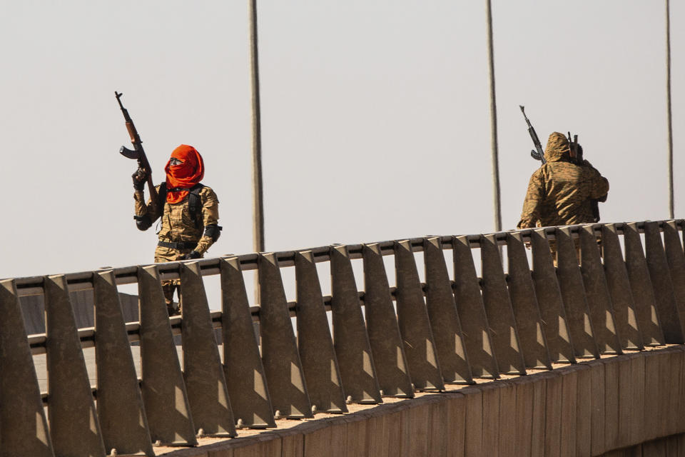 A mutinous soldier fires into the air at the Bobo interchange, near the Lamizana camp in Burkina Faso's capital Ouagadougou Sunday Jan. 23, 2022. Witnesses are reporting heavy gunfire at a military base raising fears that a coup attempt is underway. Government spokesman Alkassoum Maiga acknowledged the gunfire but denied that the military had taken over the West African country. (AP Photo/Sophie Garcia)