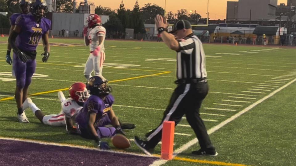 Camden's Jahleer Stanley (21) and Jamile Gantt of Paulsboro look for the official's ruling after Stanley stretched to the goal line for the first touchdown of their West Jersey Football League game on Friday, October 14, 2022.