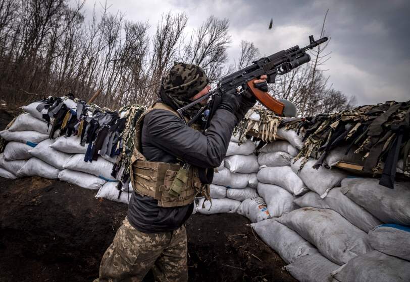 A Ukrainian serviceman shoots with an assault rifle from a trench at the front line east of Kharkiv on March 31, 2022. - Russian forces are repositioning in Ukraine to strengthen their offensive on the Donbass, Nato said on March 31, 2022, on the 36th day of the Russian-Ukrainian conflict, as shelling continues in Kharkiv (north) and Mariupol (south). (Photo by FADEL SENNA / AFP) (Photo by FADEL SENNA/AFP via Getty Images)