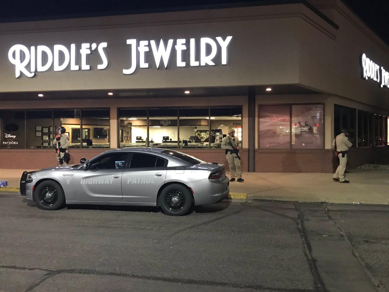 National Guard troops stand outside Riddle's Jewelry on May 31, 2020 after several people broke windows at the store.