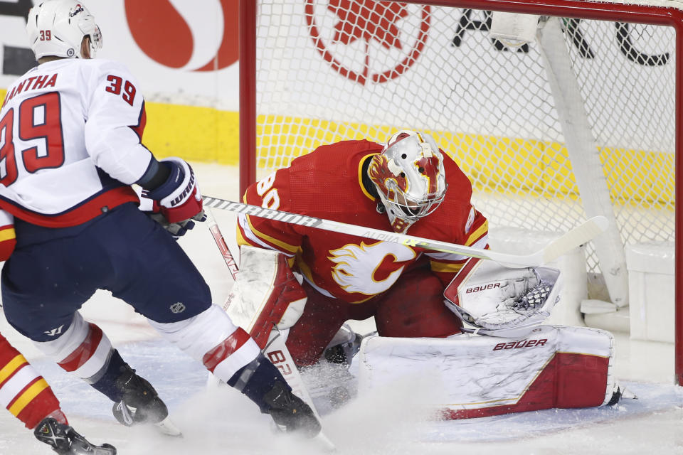 Calgary Flames goalie Dan Vladar, right, makes a save against Washington Capitals' Anthony Mantha during the first period of an NHL hockey game Tuesday, March 8, 2022, in Calgary, Alberta. (Larry MacDougal/The Canadian Press via AP)