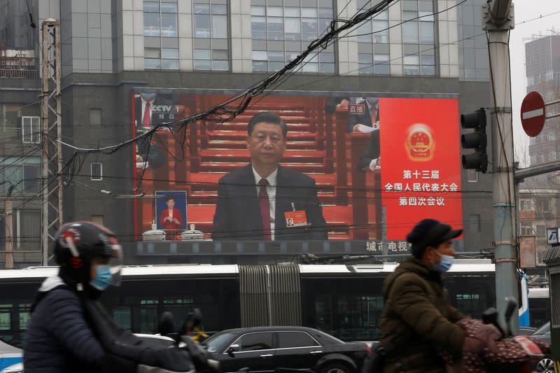 A giant screen shows Chinese President Xi Jinping attending the opening session of the National People's Congress (NPC) at the Great Hall of the People, in Beijing