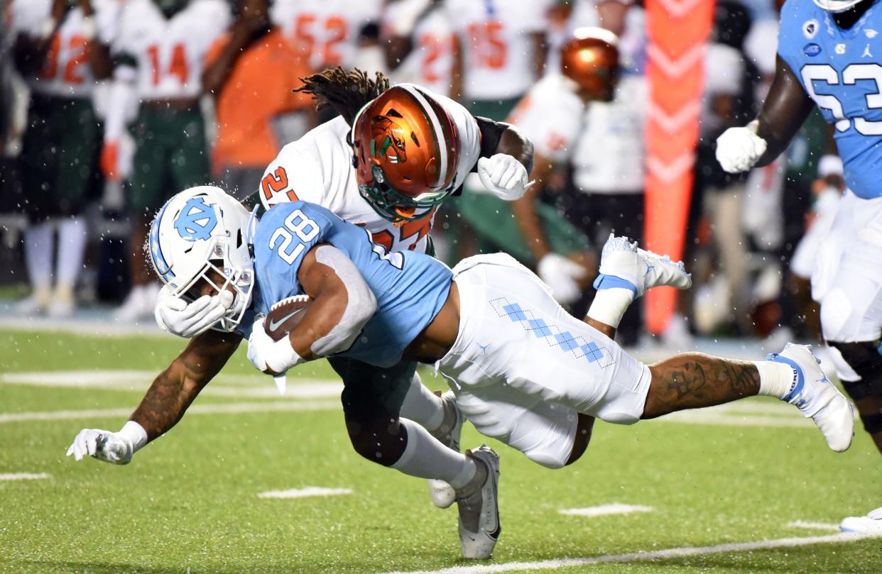 North Carolina running back Omorion Hampton dives for yards as Florida A&M linebacker Nadarius Fagan makes the tackle.