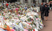 <p>The Queen and Prince Philip view the thousands of flowers and tributes left outside Kensington Palace in memory of Diana, Princess of Wales, on 5 September 1997. Diana died in a car crash in Paris on 31 August that year. (AFP via Getty Images)</p> 