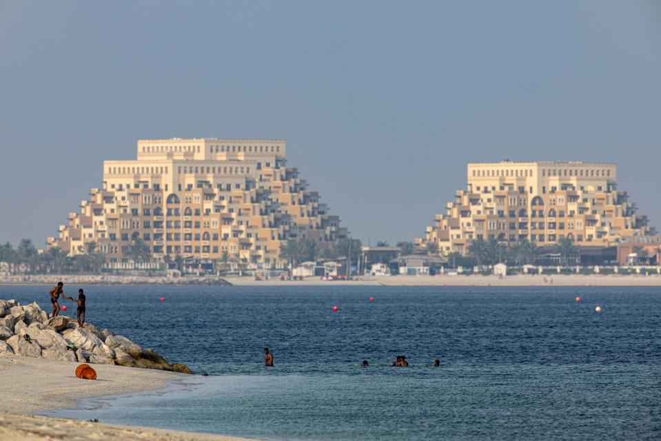 Beachgoers swim backdropped by the Rixos Bab Al Bahr hotel on Al Marjan Island in Ras Al Khaimah, United Arab Emirates, on Sunday, June 25, 2023. (Christopher Pike/Bloomberg)