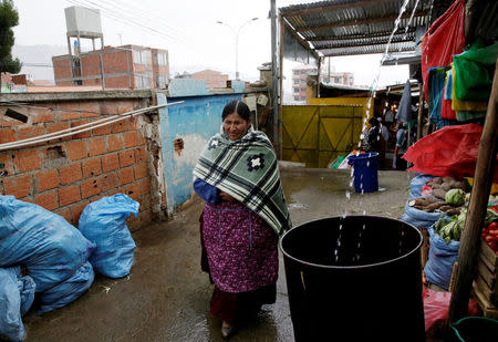 A woman walks next to a rain water barrel during a water drought season in Chasquipampa, La Paz, Bolivia, November 28, 2016. REUTERS/David Mercado