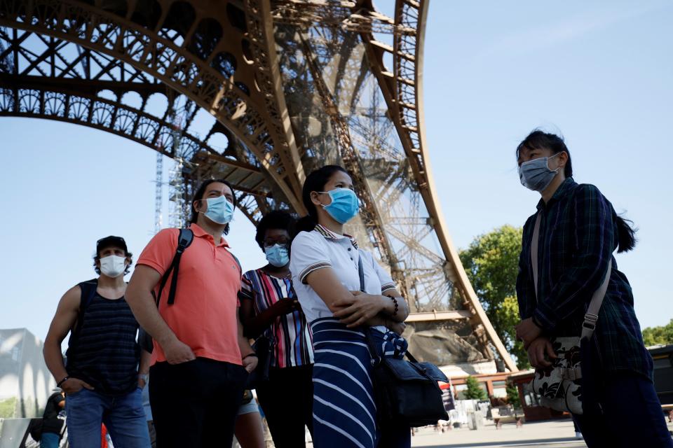 Visitors wearing protective face masks wait for the partial reopening of Eiffel Tower on June 25, 2020, in Paris. / Credit: THOMAS SAMSON/AFO via Getty Images