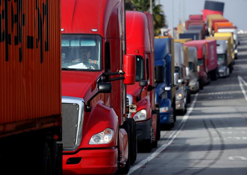 LONG BEACH, CALIF. - NOV. 18, 2021. Trucks idle in a long line as drivers wait to enter a shipping terminal in the Port of Long Beach on Thursday, Nov. 18, 2021. (Luis Sinco / Los Angeles Times)