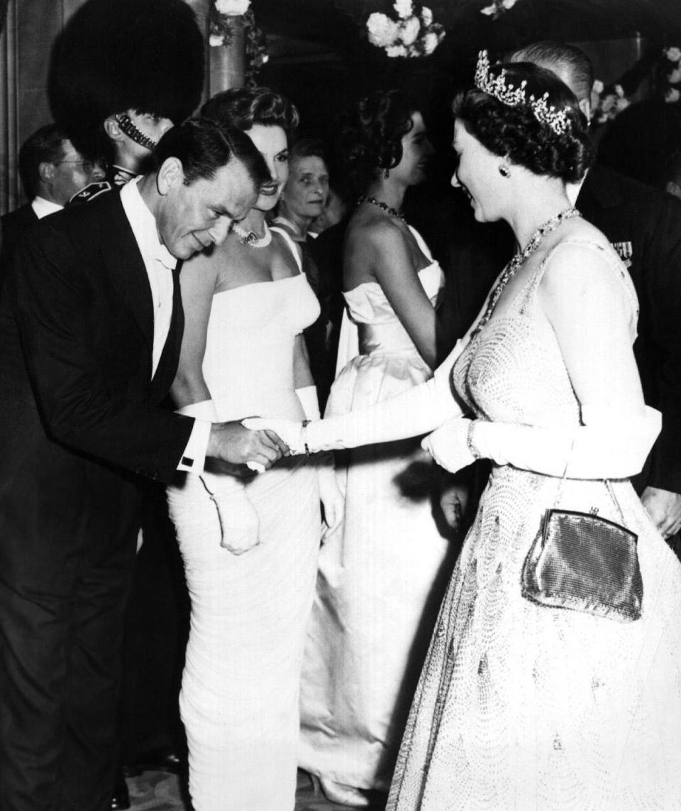 Frank Sinatra: Frank Sinatra bows his head as he shakes hands with the Queen at a London premiere, 1958 (Rex Features)