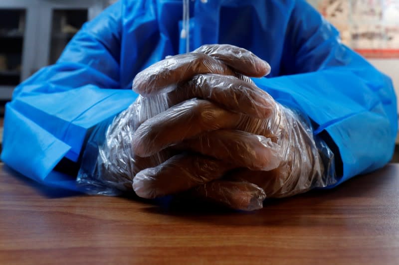 A volunteer of the Edhi Foundation, a non-profit social welfare programme, wears disposable polythene gloves during an awareness session on handling suspected carriers of coronavirus disease (COVID-19), in Karachi, Pakistan