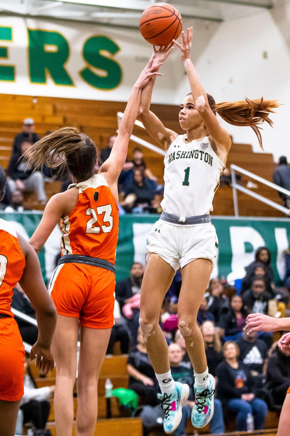 Washington's Amiyah Reynolds (1) shoots as Fort Wayne Northrop's Saniya Jackson (23) defends during the Washington vs. Fort Wayne Northrop girls basketball game Wednesday, Jan. 18, 2023 at Washington High School.