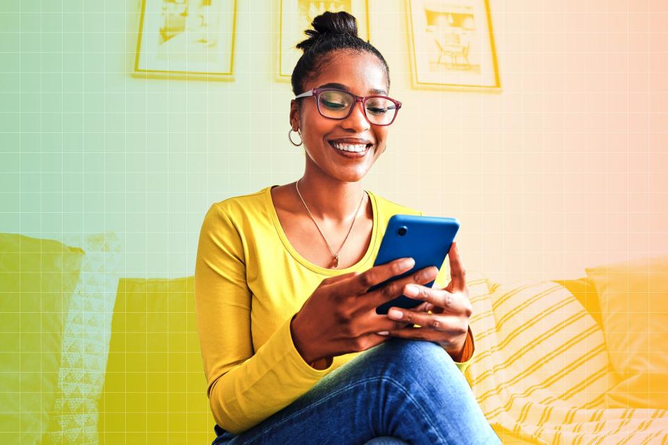 Shot of a young woman using a cellphone while relaxing on a sofa at home