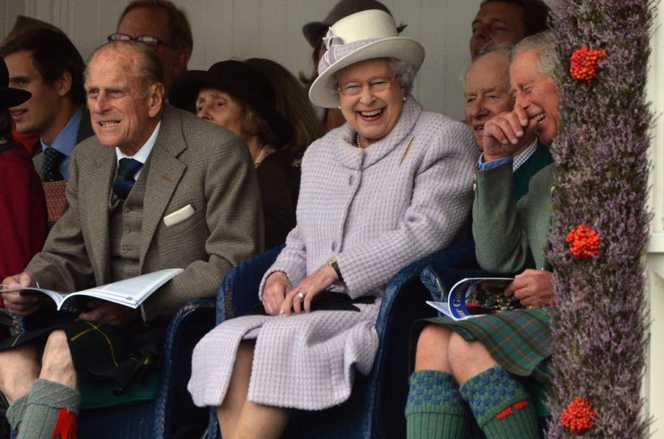 Members of Britain's royal family (front L to R) Prince Philip, Queen Elizabeth and Prince Charles cheer as competitors participate in a sack race at the Braemar Gathering in Braemar, Scotland, 2012 (Getty Images)