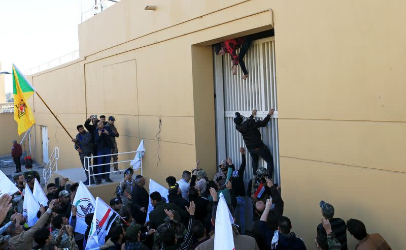 Hashd al-Shaabi fighters try to enter the U.S. Embassy during a protest to condemn air strikes on their bases, in Baghdad