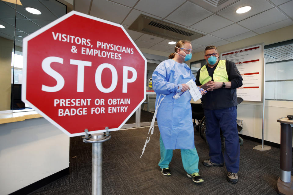 Medical personnel discuss patients that had been admitted for testing for the coronavirus at the entrance Central Maine Medical Center Friday, March 13, 2020, in Lewiston, Maine.  (Robert F. Bukaty/AP)