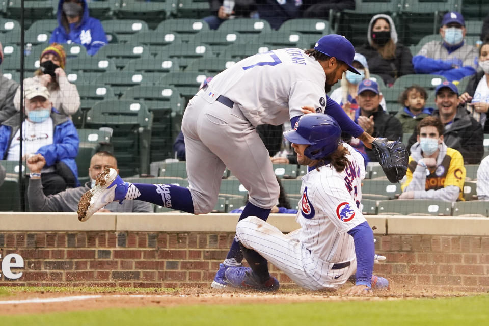 Chicago Cubs' Jake Marisnick, right, slides safely into home plate as Los Angeles Dodgers relief pitcher Dennis Santana (77) tries to make a tag during the third inning of the first baseball game of a doubleheader Tuesday, May, 4, 2021, in Chicago. (AP Photo/David Banks)