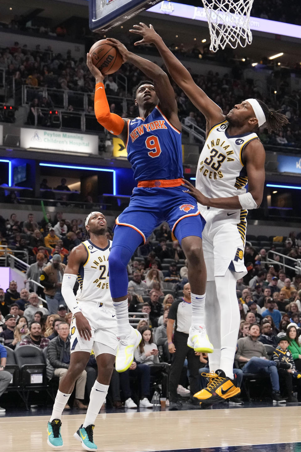 New York Knicks guard RJ Barrett (9) shoots around Indiana Pacers center Myles Turner (33) during the first half of an NBA basketball game in Indianapolis, Sunday, Dec. 18, 2022. (AP Photo/AJ Mast)