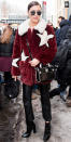 <p>After walking at Carolina Herrera's runway show, Hadid stepped out in crop-flare leather pants, patent leather booties, and a red fur coat patterned with large white stars. She finished the look with a structured black cross-body bag and oversize Vera Wang sunnies.</p>